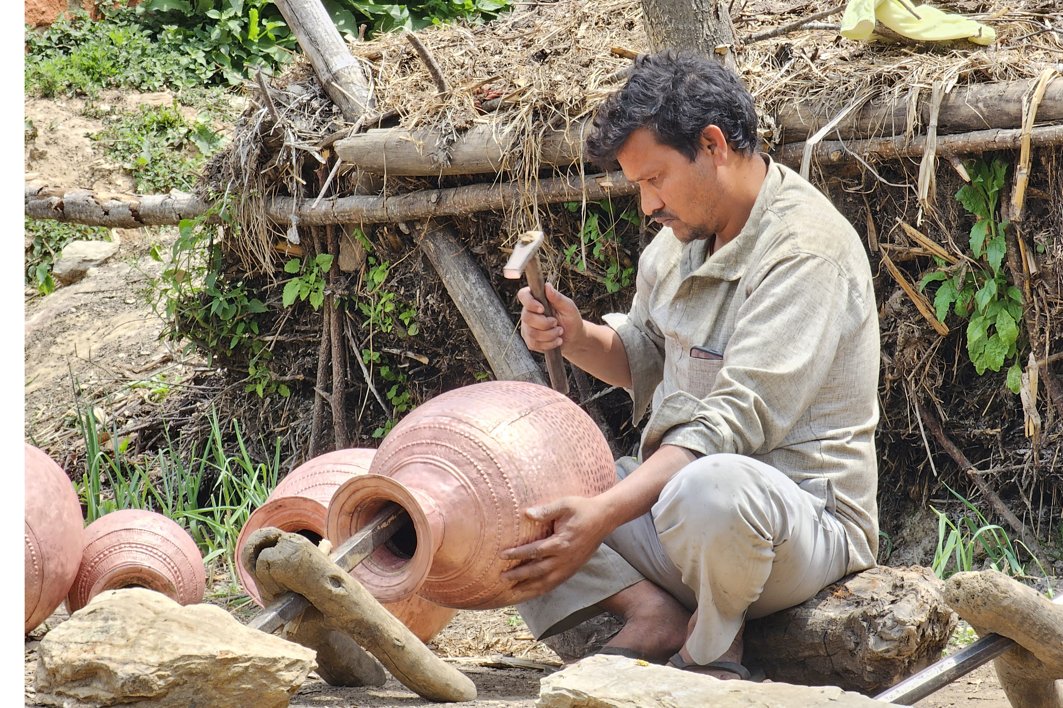 तामाको भाँडा बनाउँदै